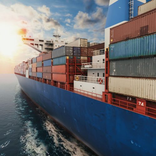 Container cargo ship sailing at sea during sunset, side view (1)