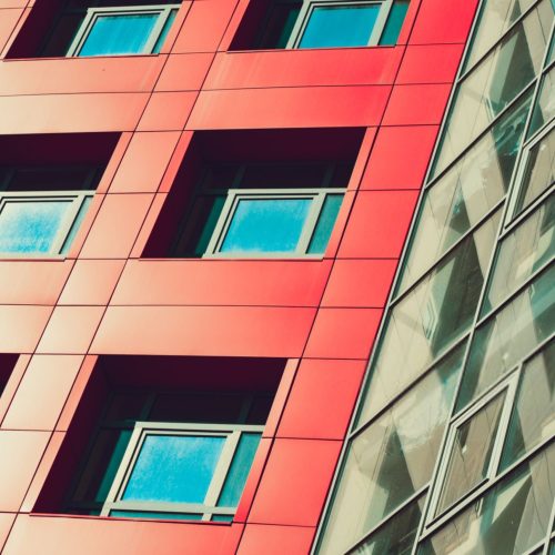 Deel van de gevel gebouw met vierkante ramen en rode muren g