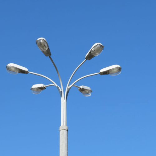 Straat_lamp_met_meerdere_lichten_geïsoleerd_op_de_heldere_bl